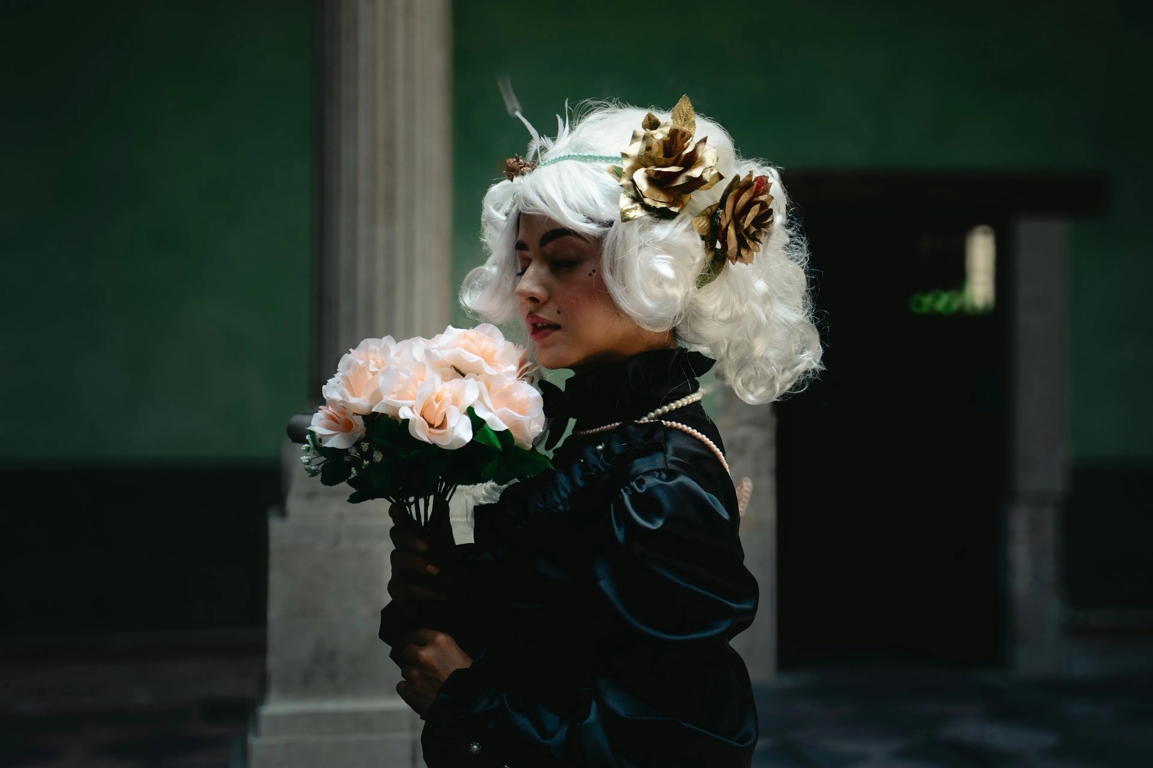 Person in historical costume holding flowers, representing the composer of the opera The Marriage of Figaro.
