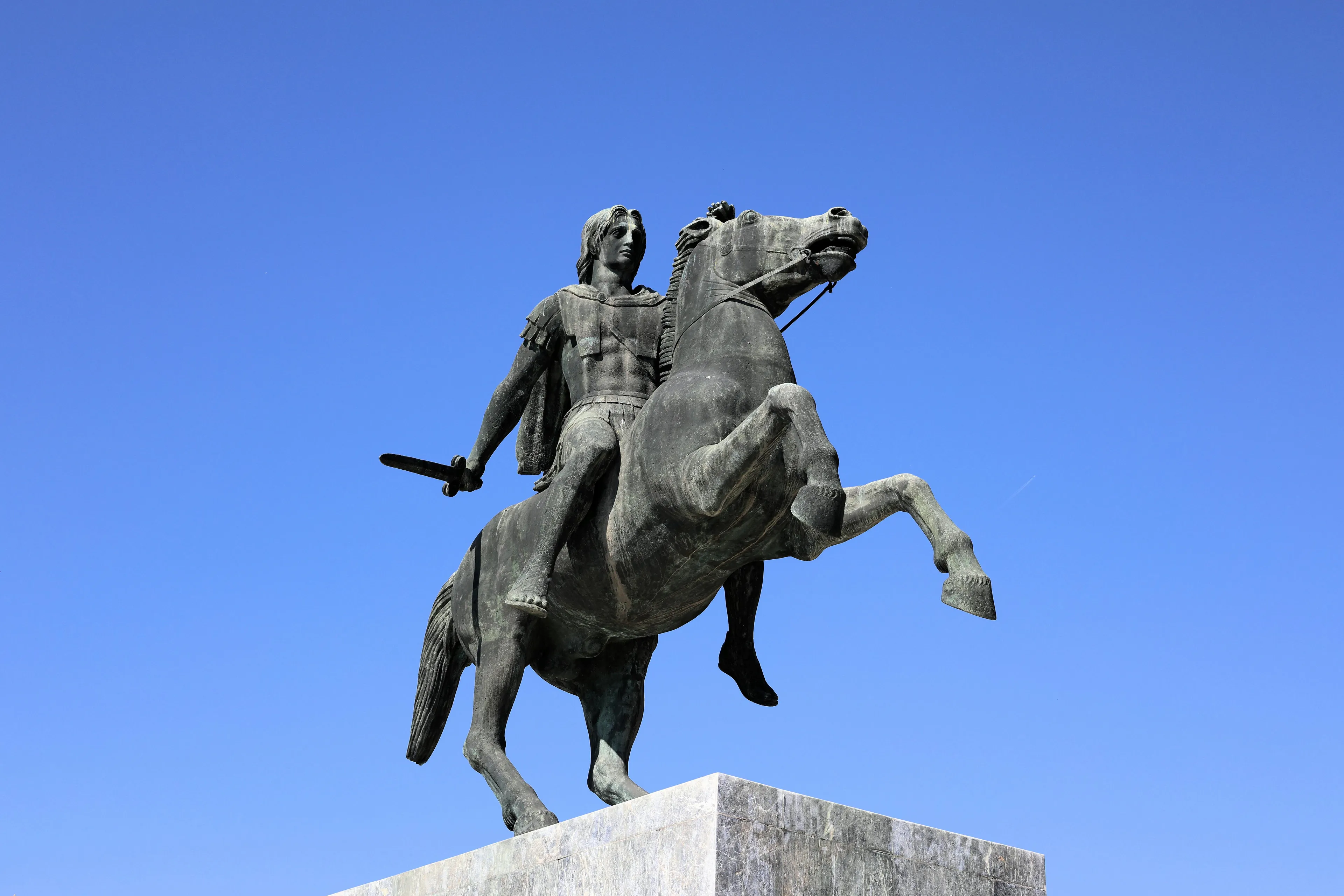 Bronze statue of Alexander the Great on horseback under clear blue sky, related to difficult general knowledge quiz.