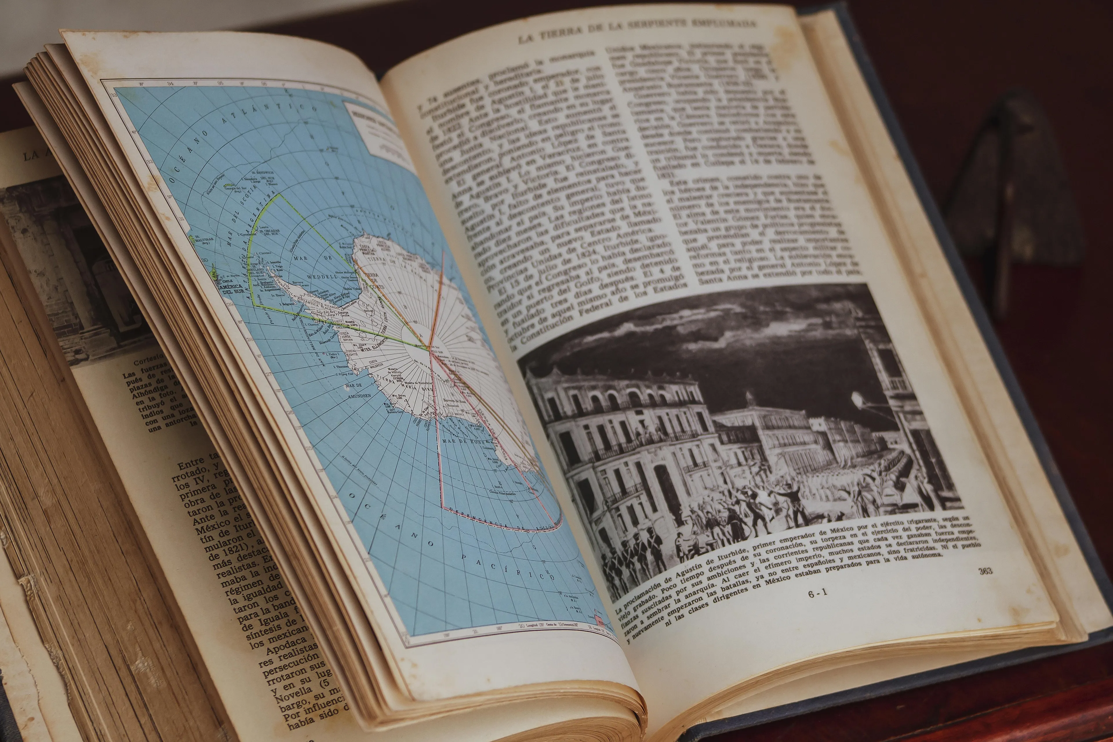 Open vintage book with a map and an illustration of an ancient city, related to ancient wonder of the world in Ephesus.