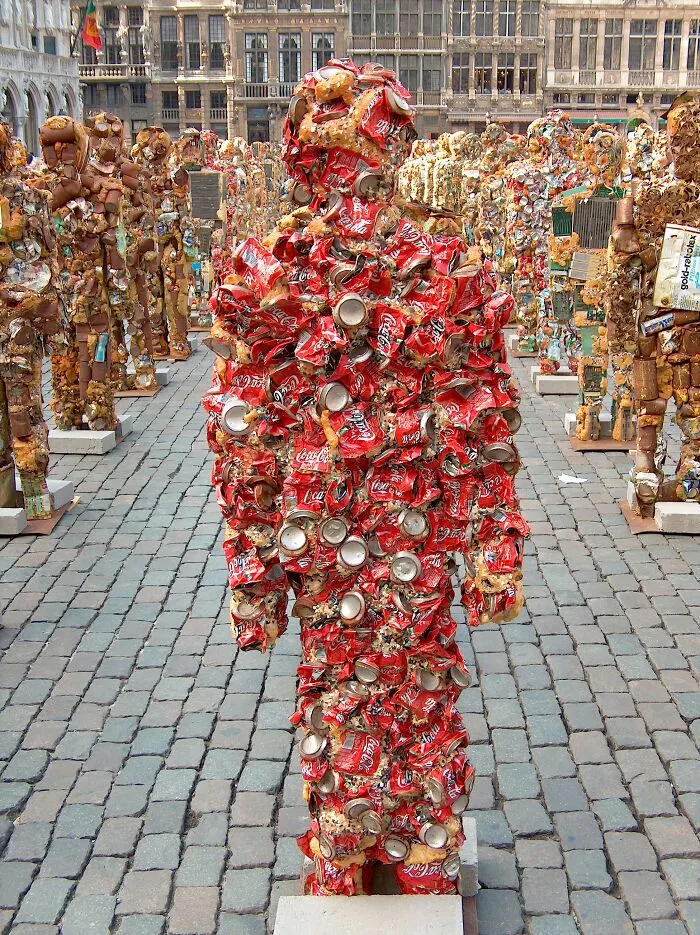 A human-shaped sculpture crafted from creative trash like crushed red Coca-Cola cans, highlighting surprisingly useful artistic reuse.