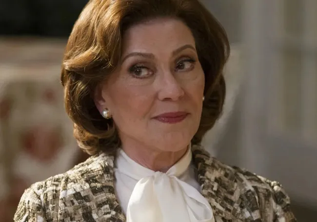 Emily Gilmore wearing a pearl earring and patterned jacket with a white blouse, showing a thoughtful expression.