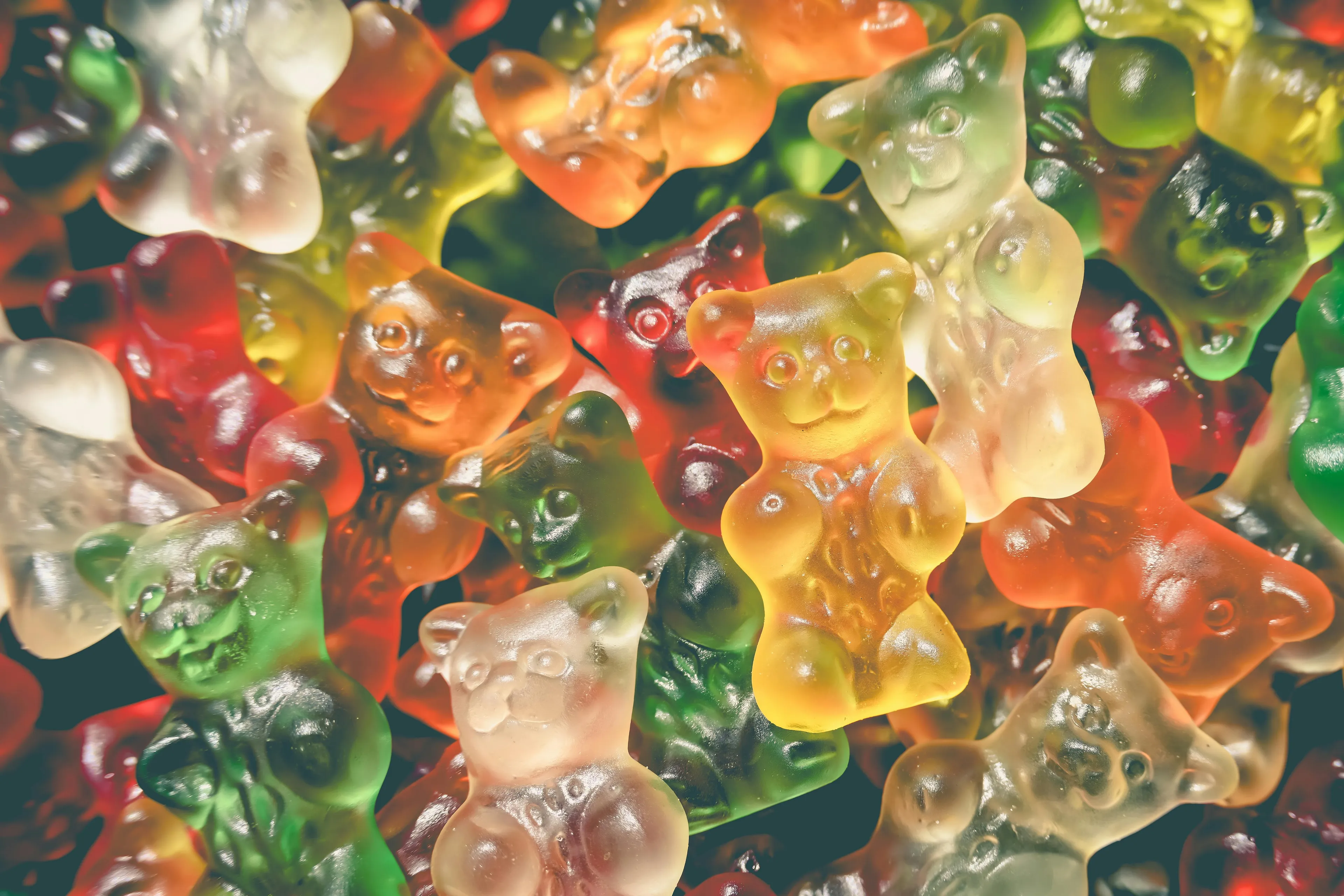 Colorful gummy bears piled together, perfect as a snack to stash in your bag for emergencies.