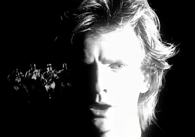 Close-up black and white image of a man singing, highlighting the theme of every breath you take in parenting playlists.