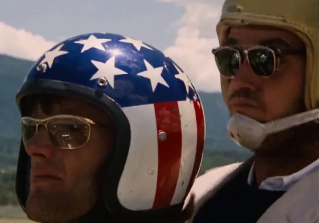 Two men wearing vintage helmets and sunglasses, embodying a born to be wild parenting playlist anthem vibe outdoors.