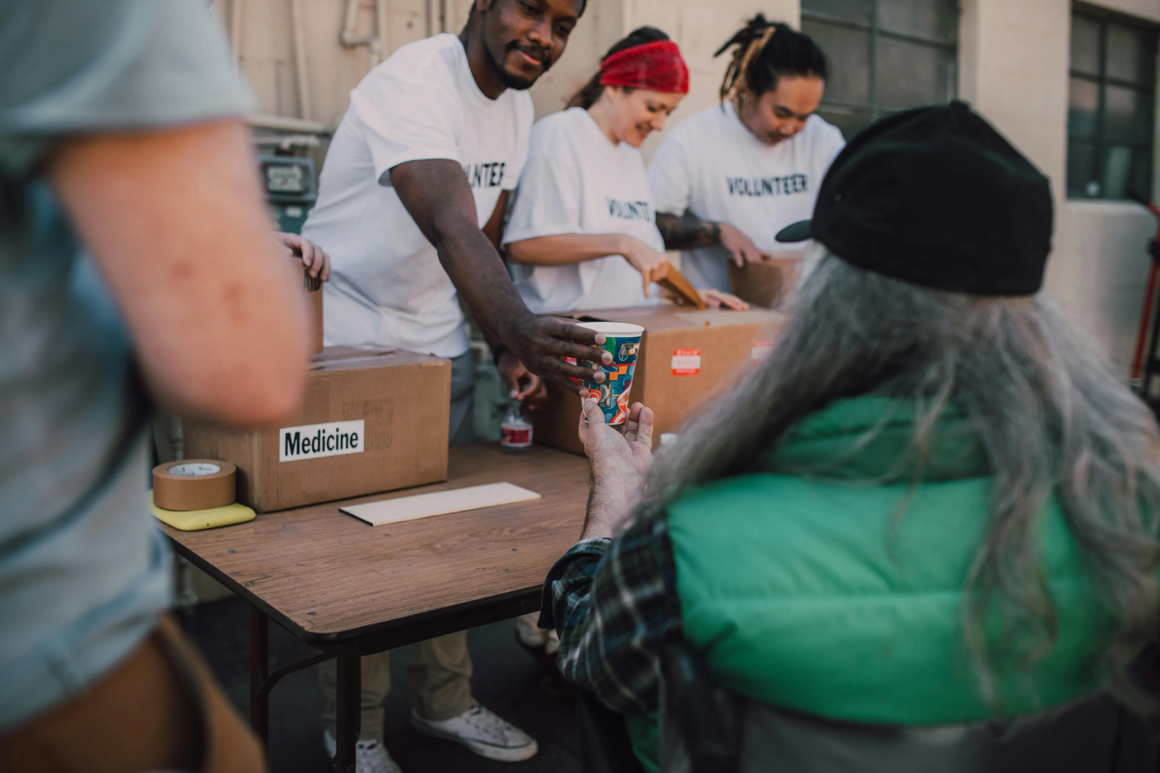 A group of volunteers handing out drinks and supplies as a weekend family activity to volunteer together.