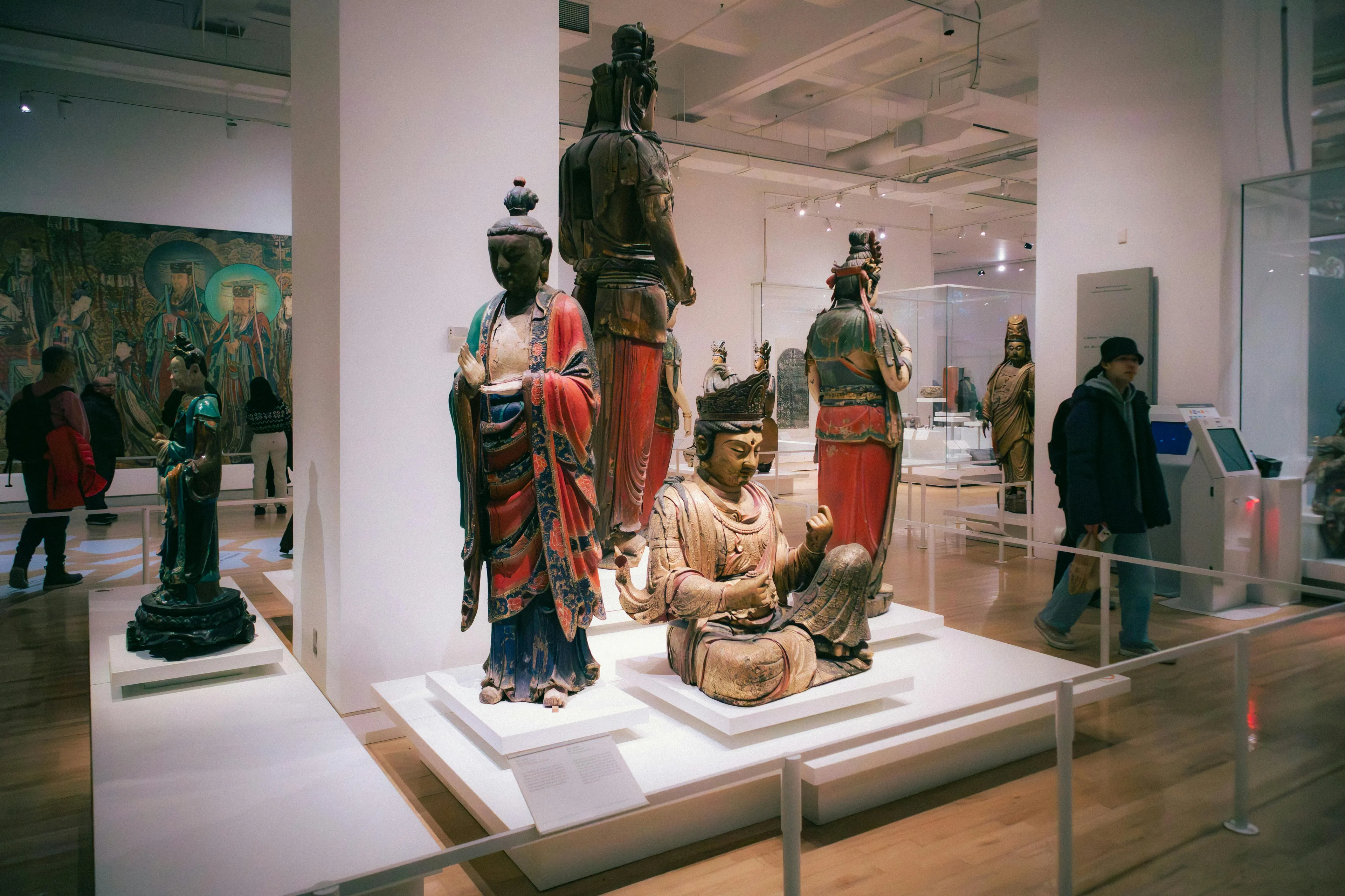 Visitors exploring ancient sculptures at a museum trip, enjoying a weekend family activity in a bright gallery space.