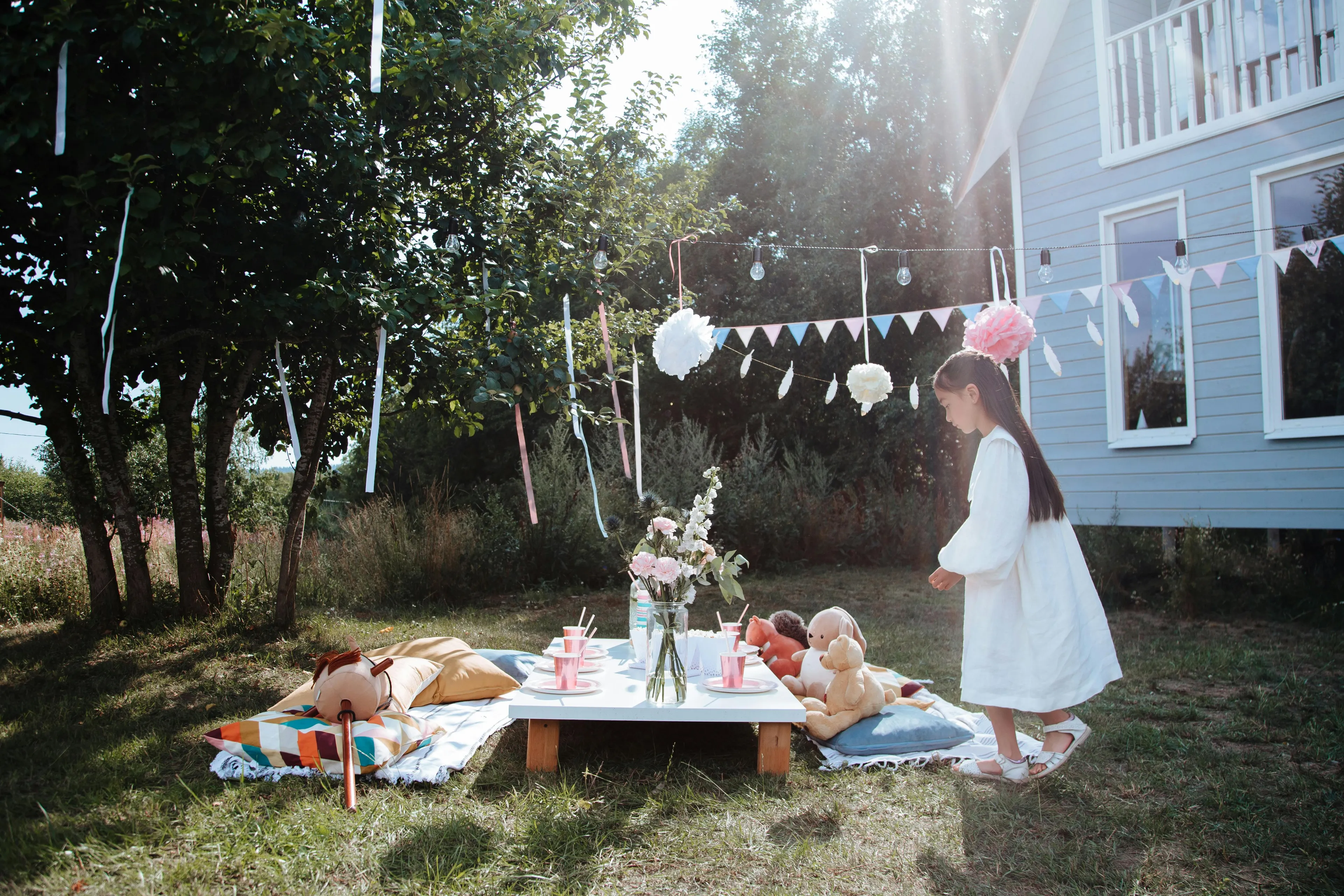 Child enjoying a backyard picnic setup with toys and decorations, perfect weekend family activity in a sunny garden.