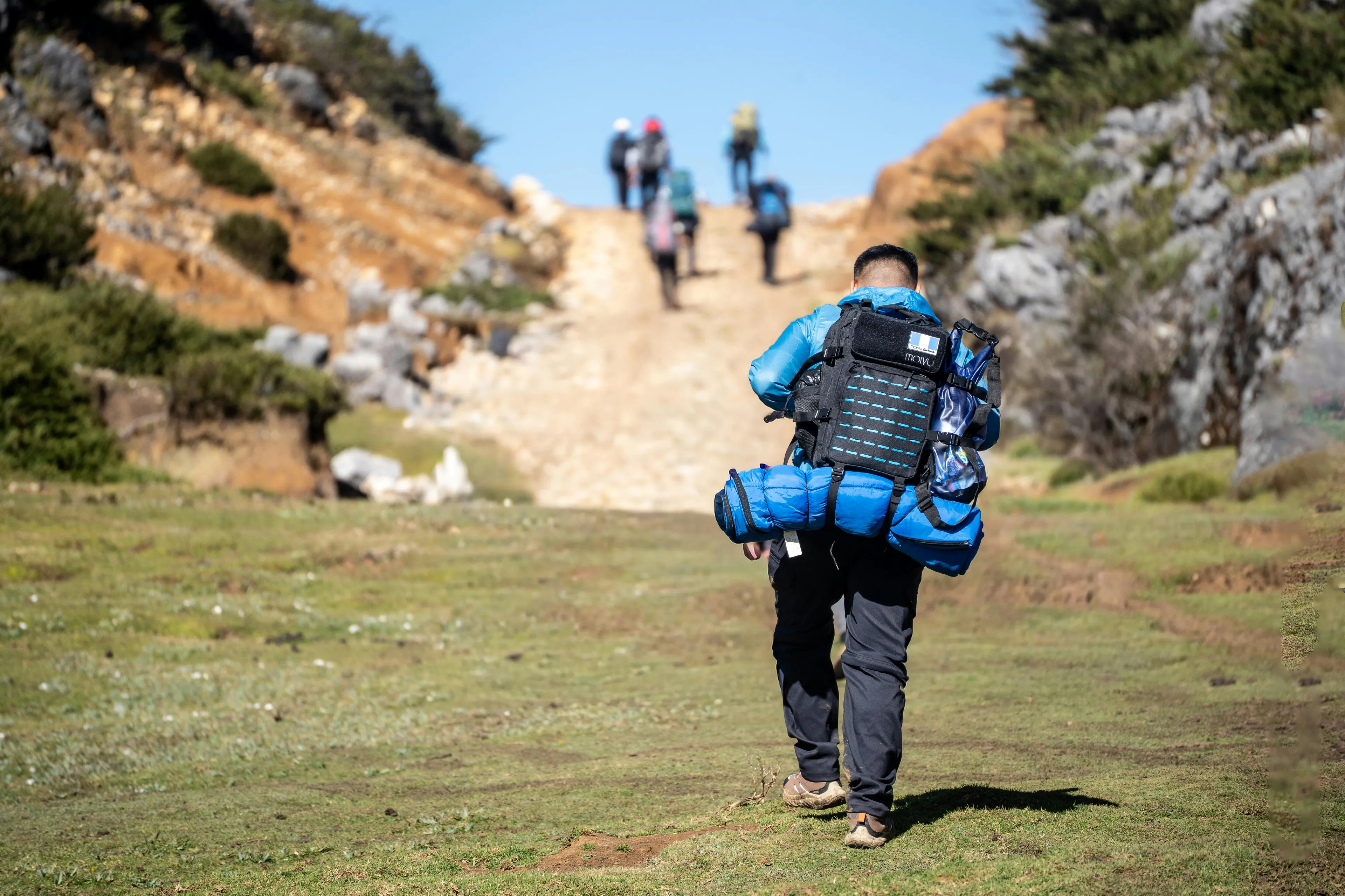 Person with backpack hiking on a trail in nature, enjoying an unplanned weekend family activity outdoors.