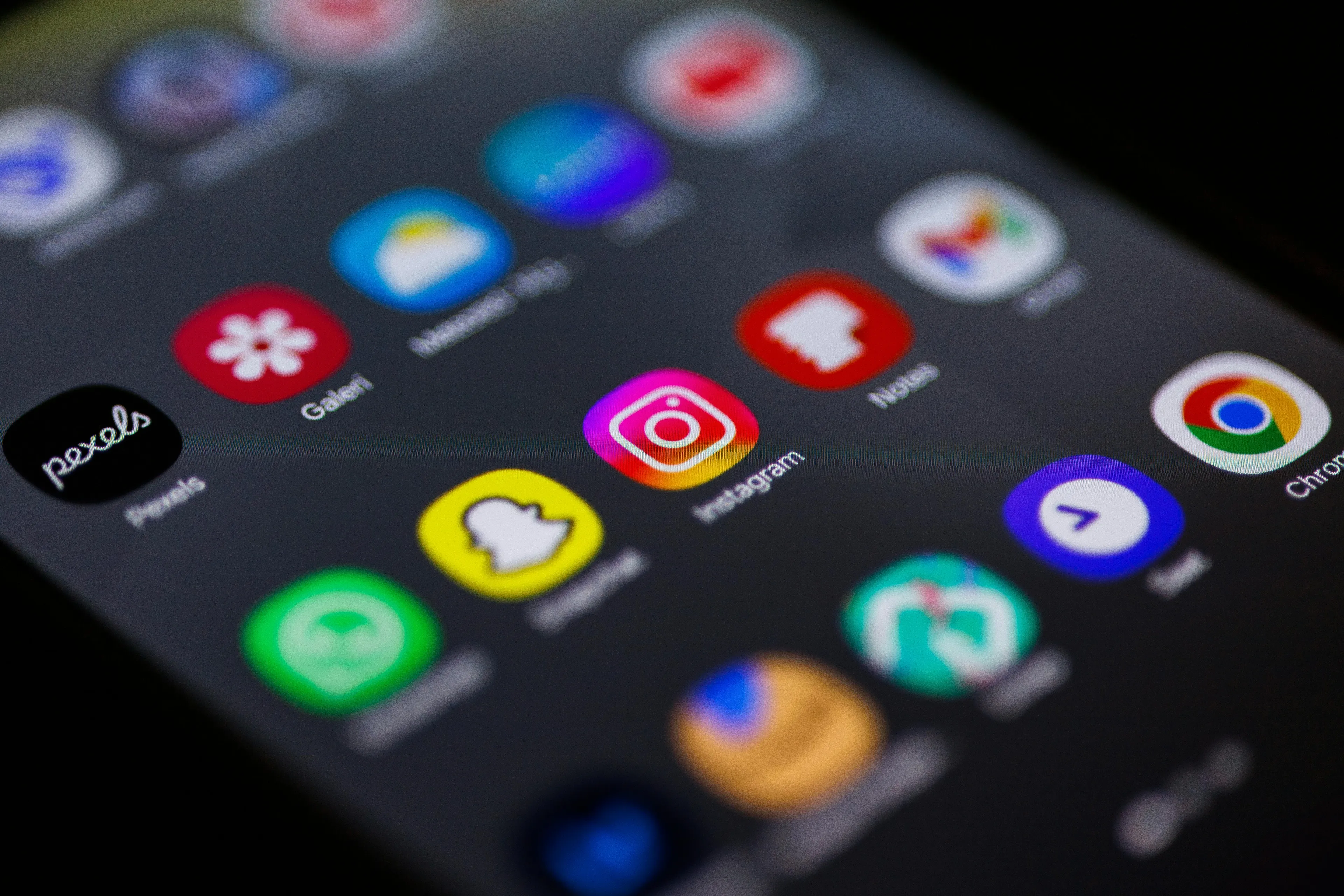 Close-up of a smartphone screen displaying social media apps, highlighting parenting style concerns and social media age limits.