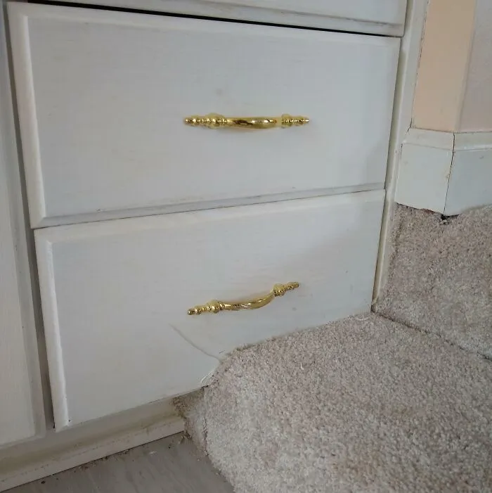 Este baño remodelado con un escalón alfombrado que bloquea un cajón del tocador.
