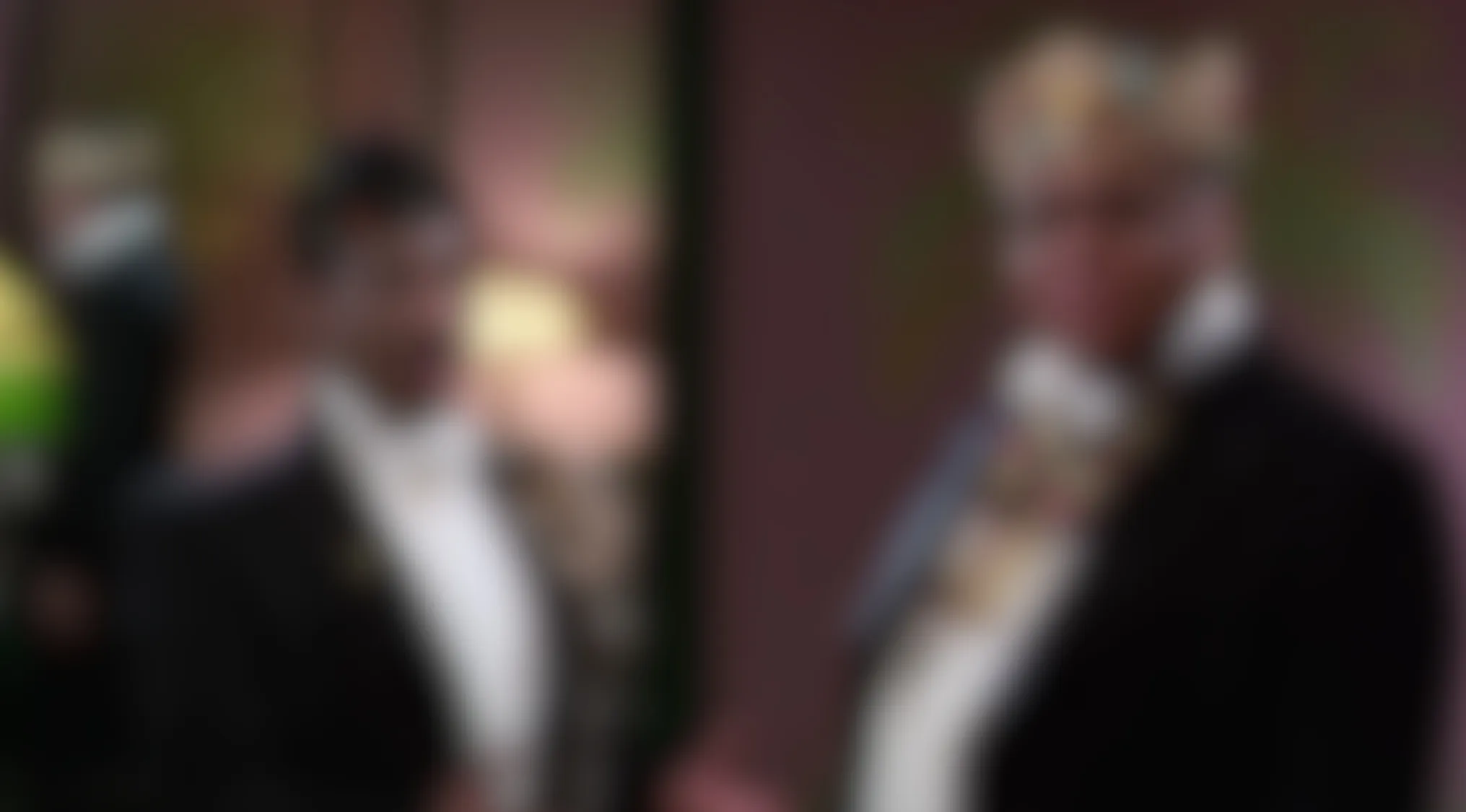 A blurry movie scene features two men in suits, one with a distinctive crown. Guess the film!