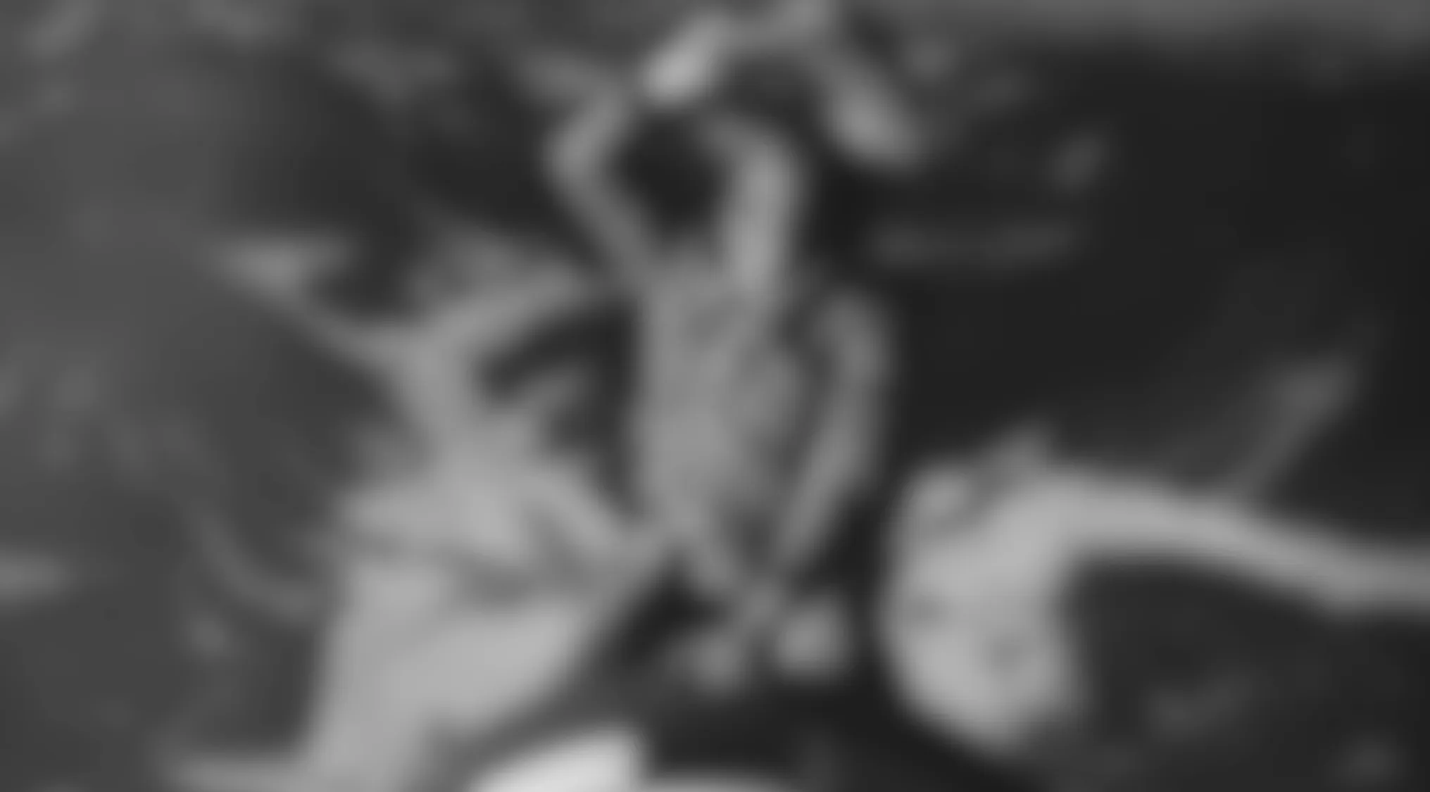A grayscale image of blurry movie scenes, featuring indistinct figures with raised arms, possibly dancing. Can you guess the film?