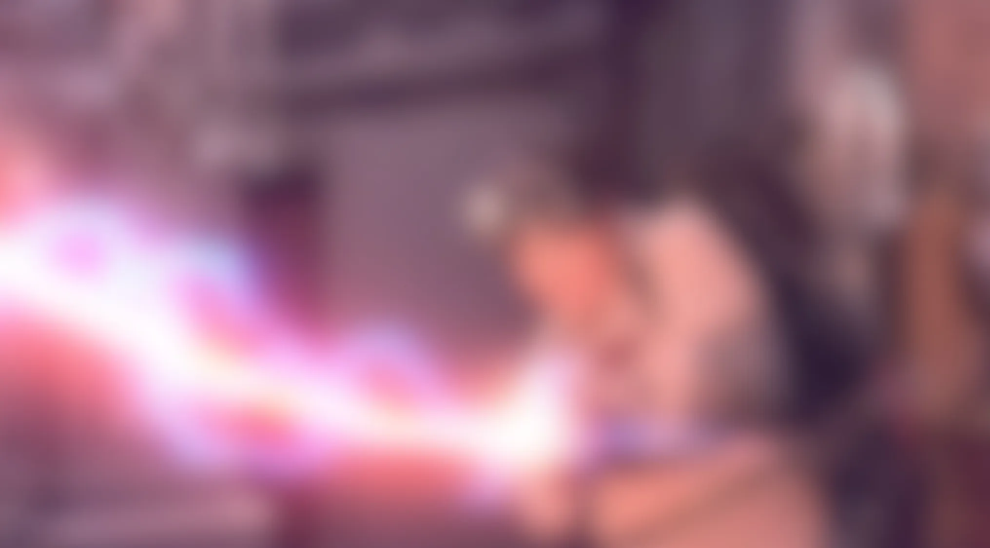 A vibrant, blurry movie scene featuring a glowing pink and purple energy beam, possibly a lightsaber or laser. Guess this scene!