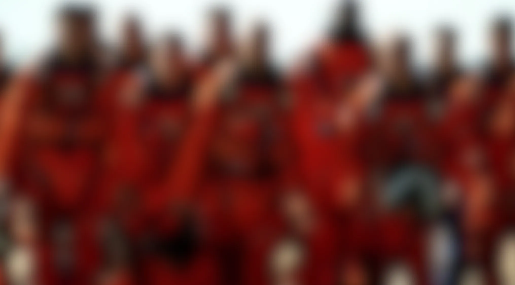 A blurry movie scene showing multiple indistinct figures in red uniforms. Guess the movie from this highly blurred image.