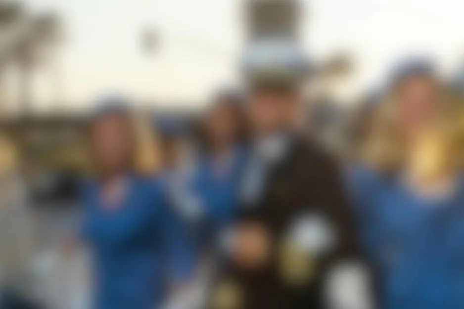 A blurry scene from Catch Me If You Can (2002) featuring a man in a dark uniform with two women in blue.