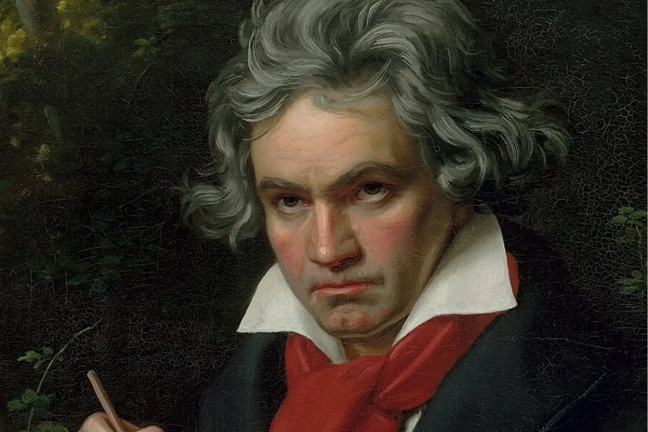 Oil painting of composer Ludwig van Beethoven with wavy grey hair, serious expression, white shirt, and red cravat.