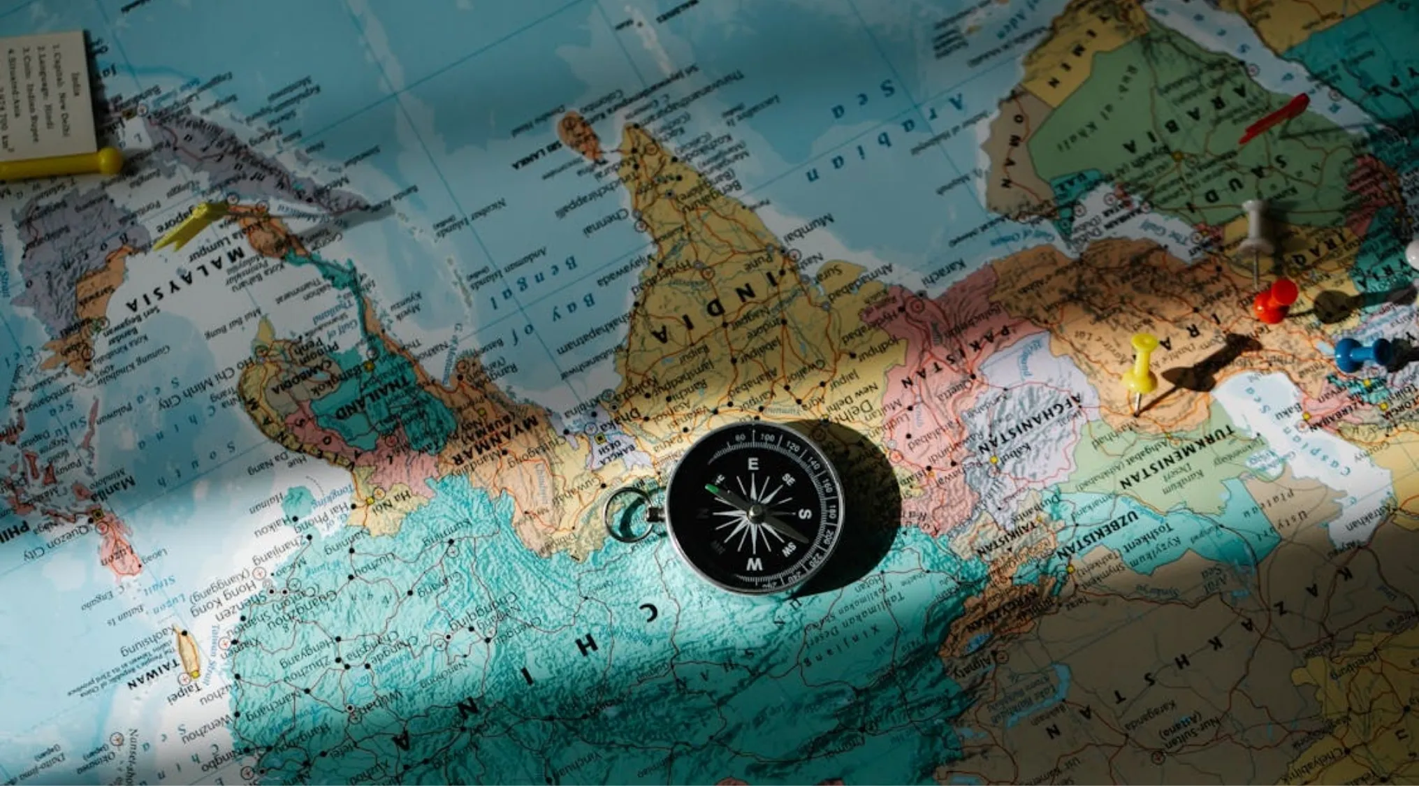 Map of Asia with a compass, pushpins, and a note, illustrating a Thomas Edison's Employment Test.