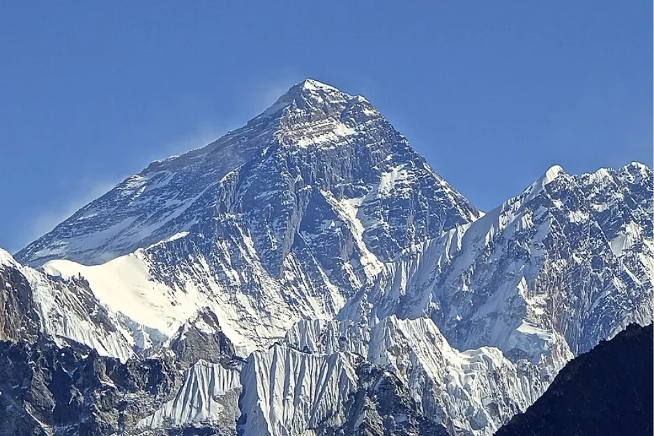 Mount Everest, the highest mountain in the world, covered in snow under a clear blue sky.
