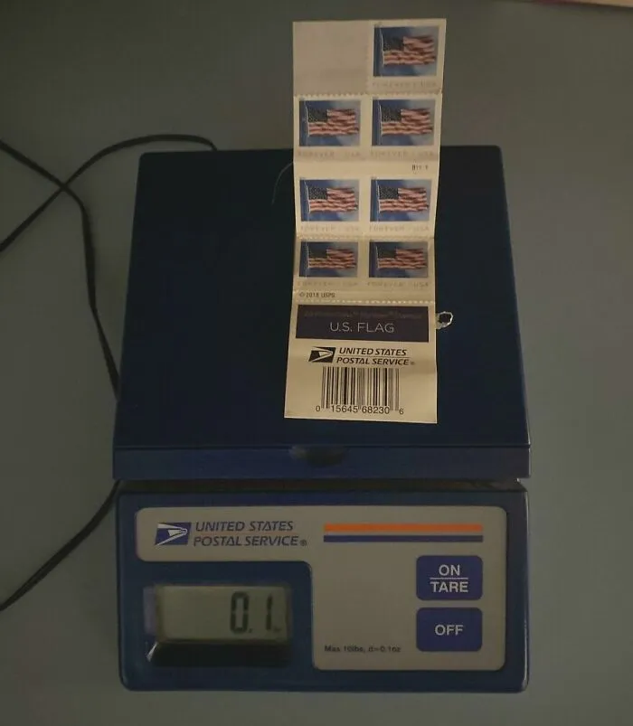 A sheet of U.S. flag stamps on a postal scale, showing the weight. A Goodwill bins find.