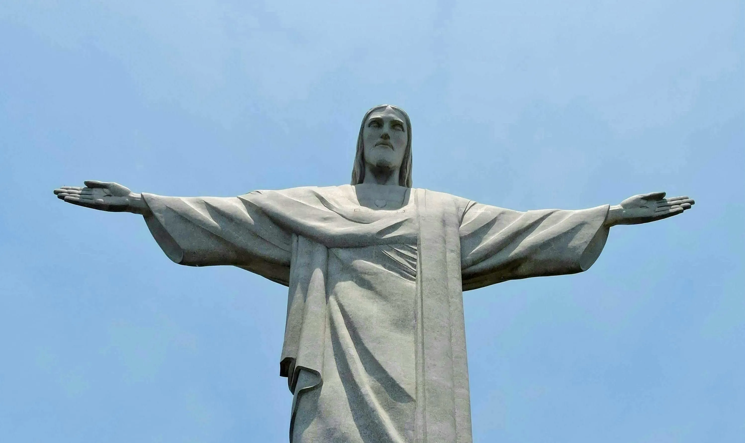 Christ the Redeemer statue against a blue sky. Guess the country from this iconic landmark.