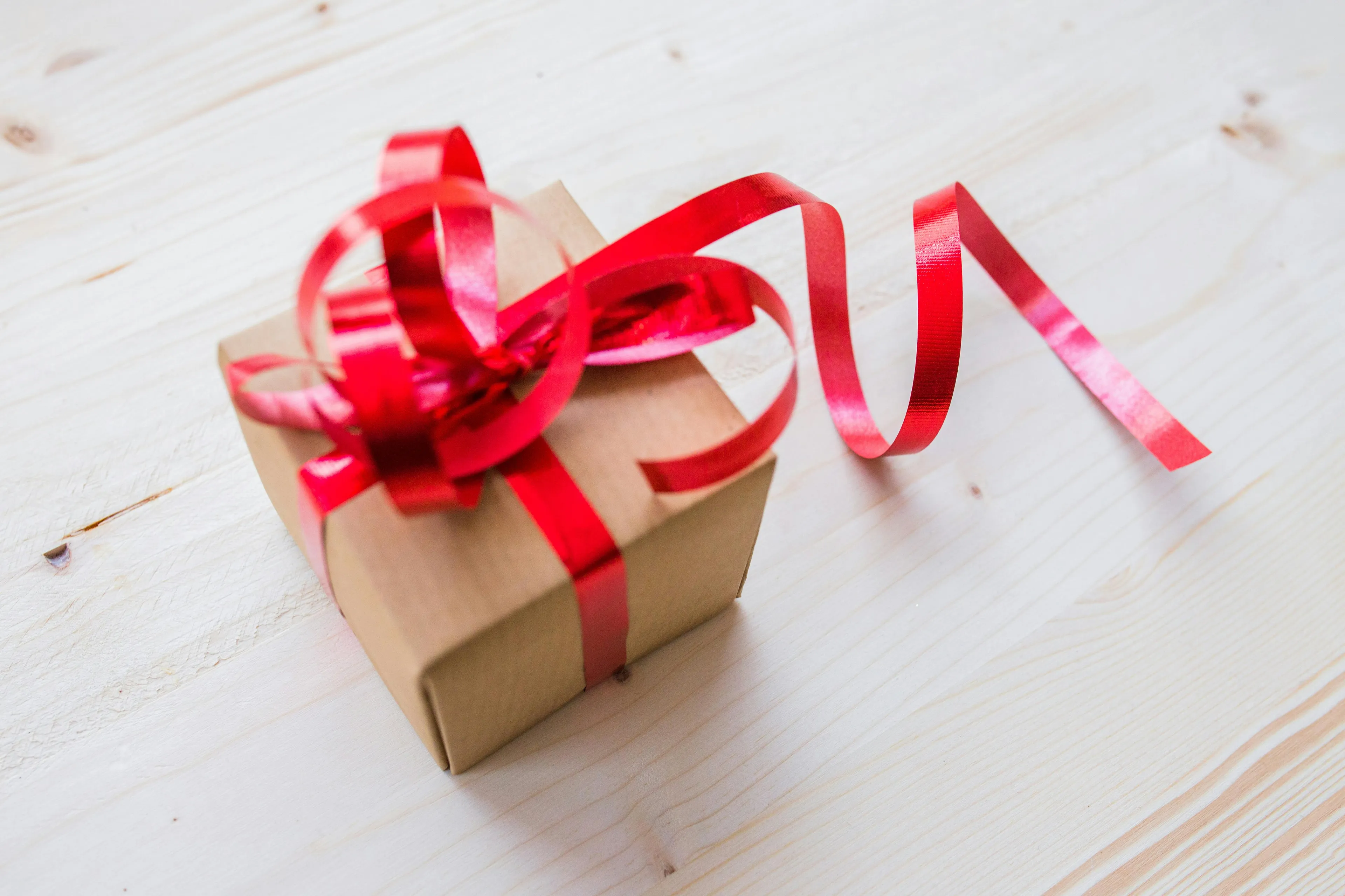 Small gift box wrapped with brown paper and a red ribbon, symbolizing a mystery prize concept for left-brain or right-brain.