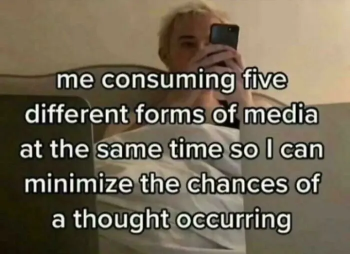 A relatable meme shows a person multitasking with multiple screens, captioned: "me consuming five different forms of media at the same time so I can minimize the chances of a thought occurring."