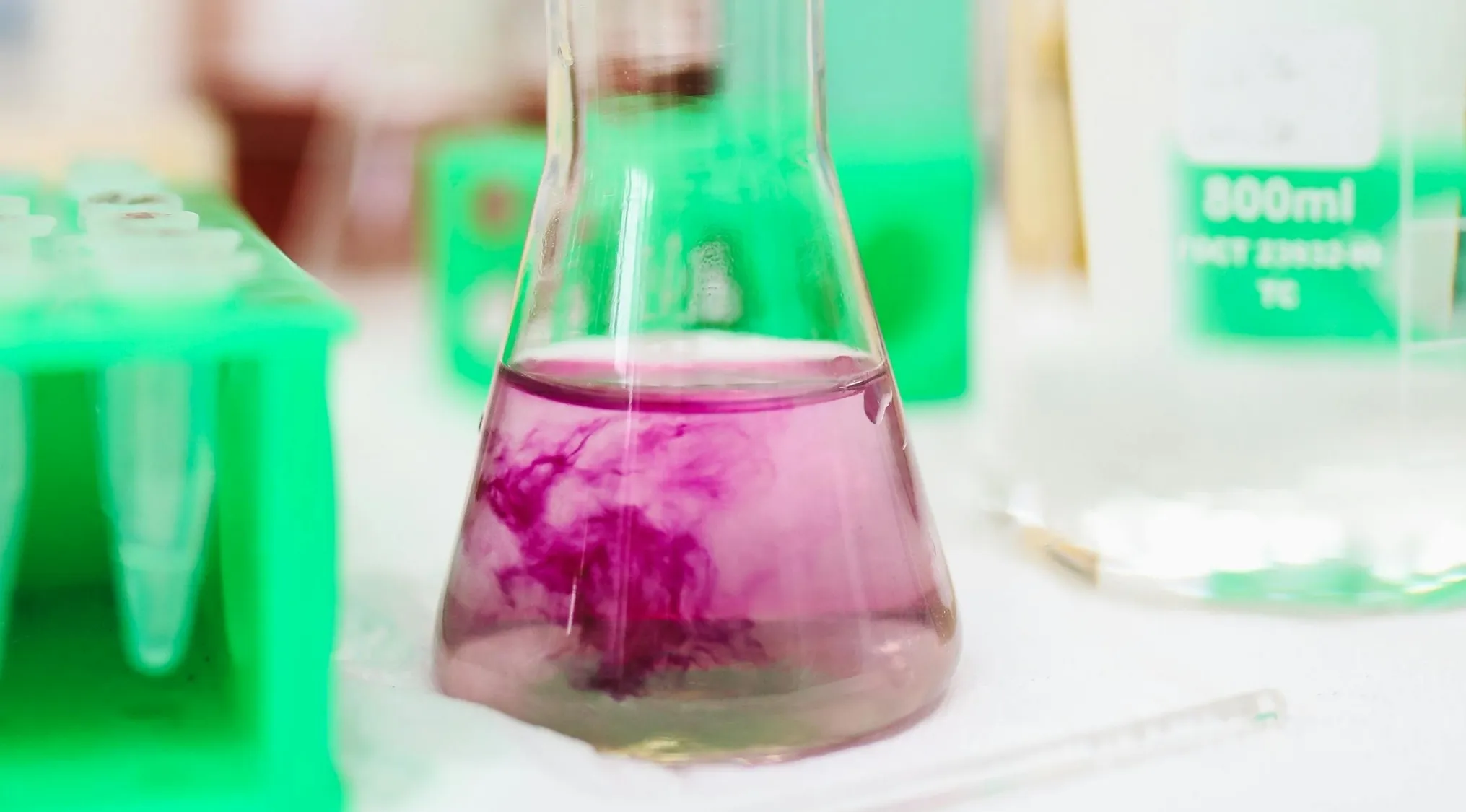 Chemistry lab flask with purple solution demonstrating concepts related to pH 9 and solution acidity or alkalinity.
