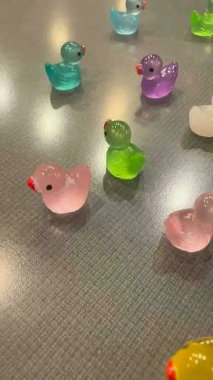 Colorful tiny rubber ducks scattered on a surface, highlighting how insulting consumerism has gotten with varied prices.