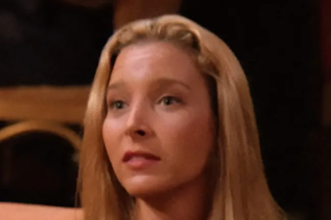 Close-up of Phoebe Buffay, looking serious, with blonde hair and light blue eyes.