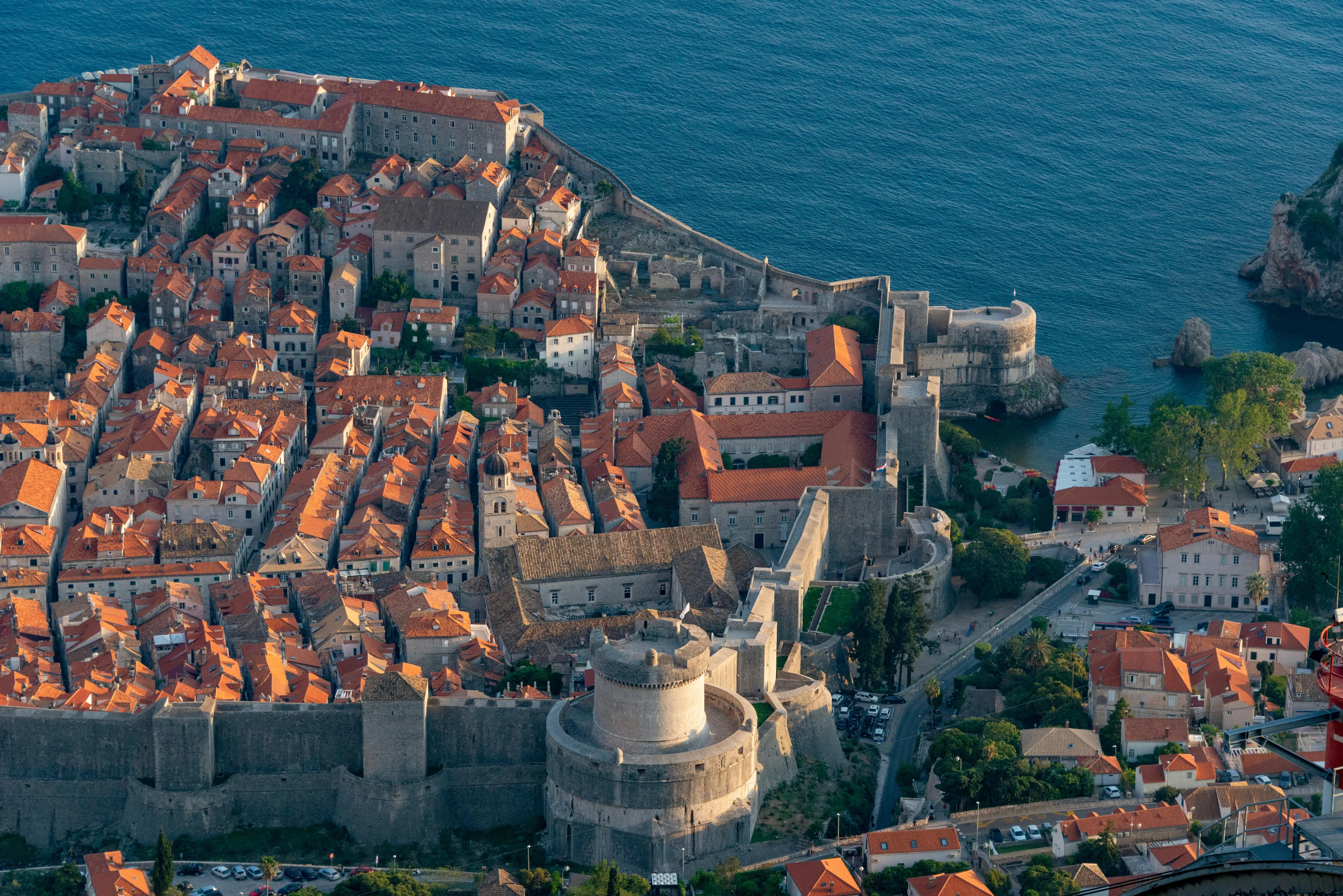 An aerial view of Dubrovnik's walled city and terracotta roofs by the deep blue sea. Test your trivia knowledge!