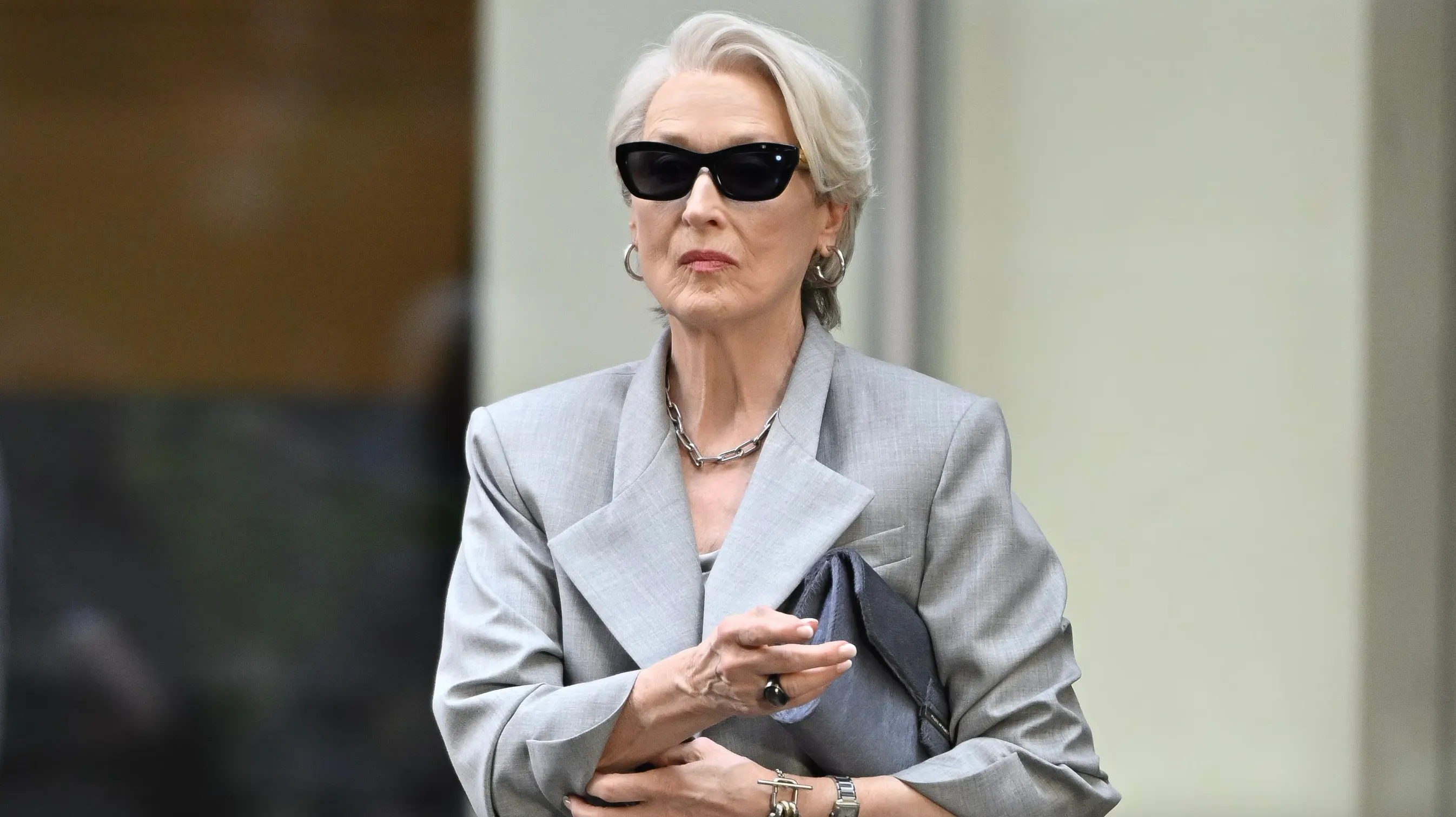 Win Trivia Night by naming the actress playing Miranda Priestly. Meryl Streep, wearing sunglasses and a gray suit.