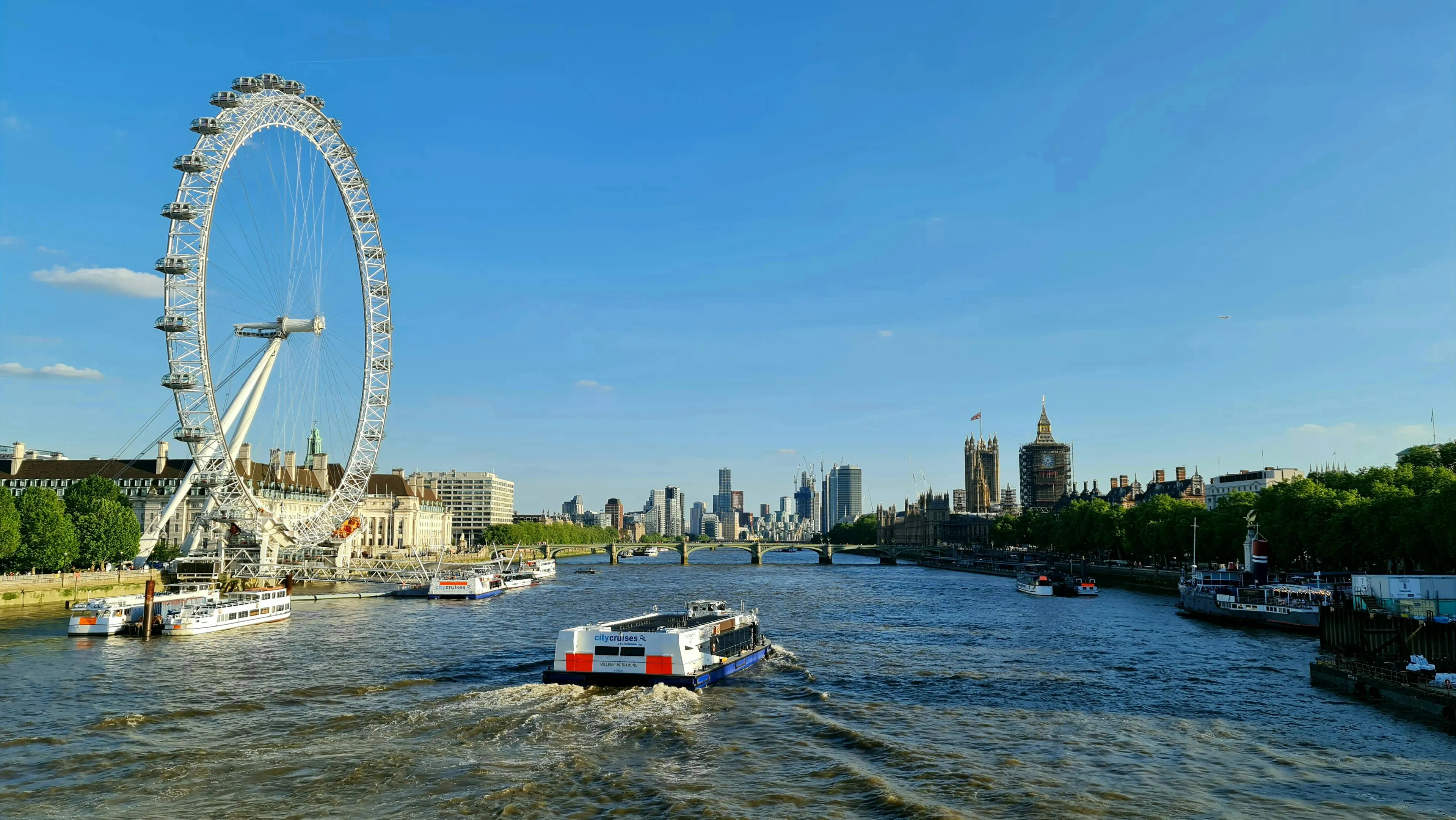 Panoramic view of the London Eye and River Thames, with Big Ben in the distance. Win trivia night with this London river.