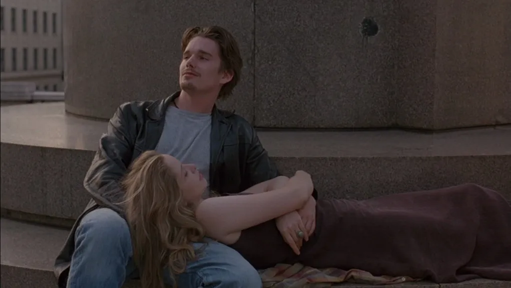 A couple relaxing on stone steps, woman lying with head on man's lap. Before Sunrise is a great comfort movie.