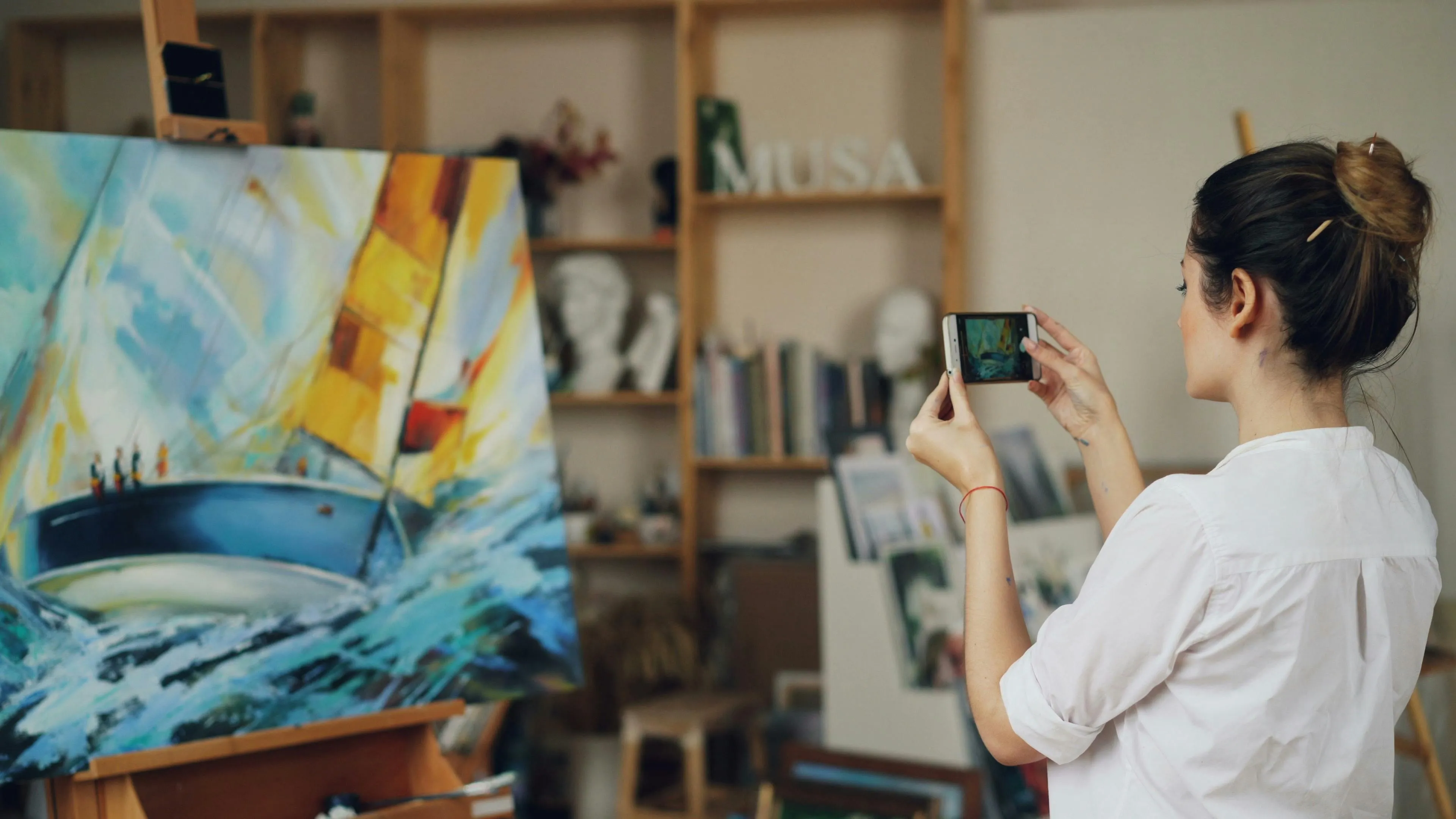 Woman photographing her painting of a sailboat with her phone; Reaction To Rejection Quiz.