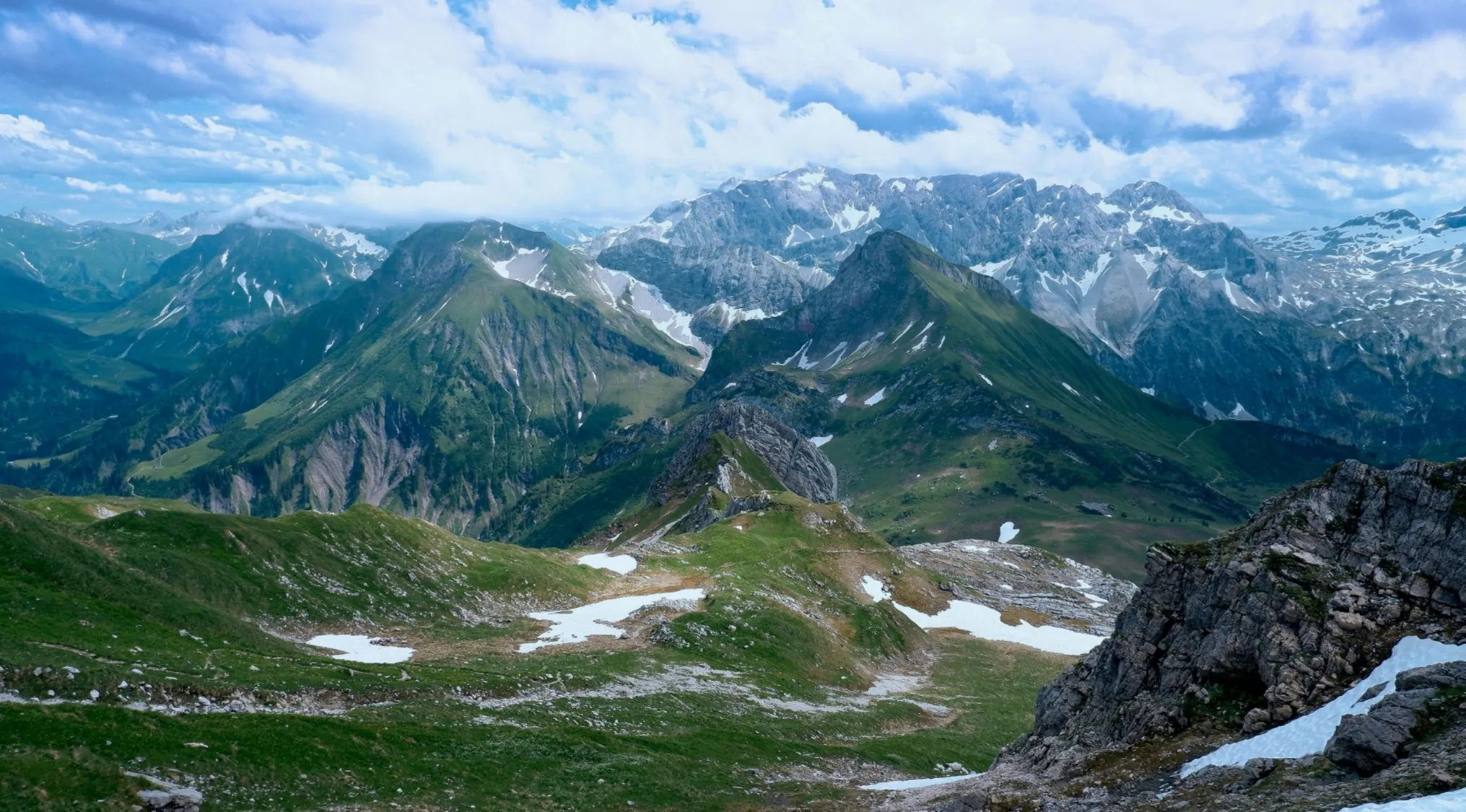 Scenic view of the green, snow-dusted Alps in Austria, setting for a famous musical movie quiz question.