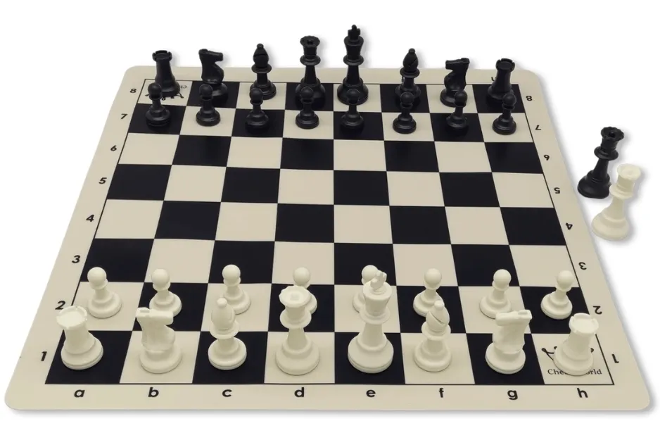 A white and black chessboard with all chess pieces set up for a game, two extra pieces are off to the side.