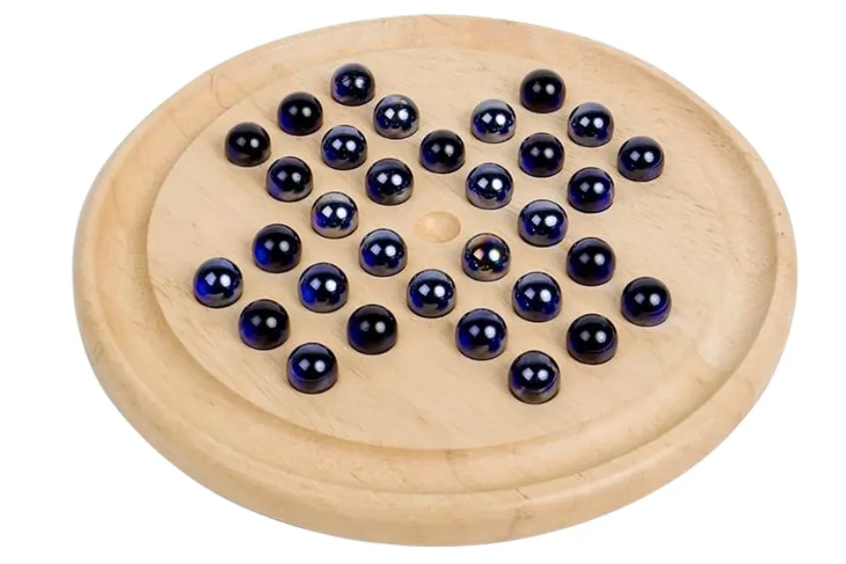 A wooden Solitaire board game with dark blue, reflective glass marbles arranged in a triangular pattern.