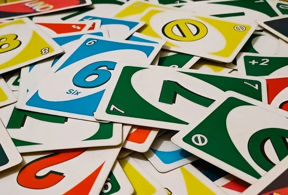 A close-up of a pile of Uno game cards in various colors: red, green, blue, and yellow.
