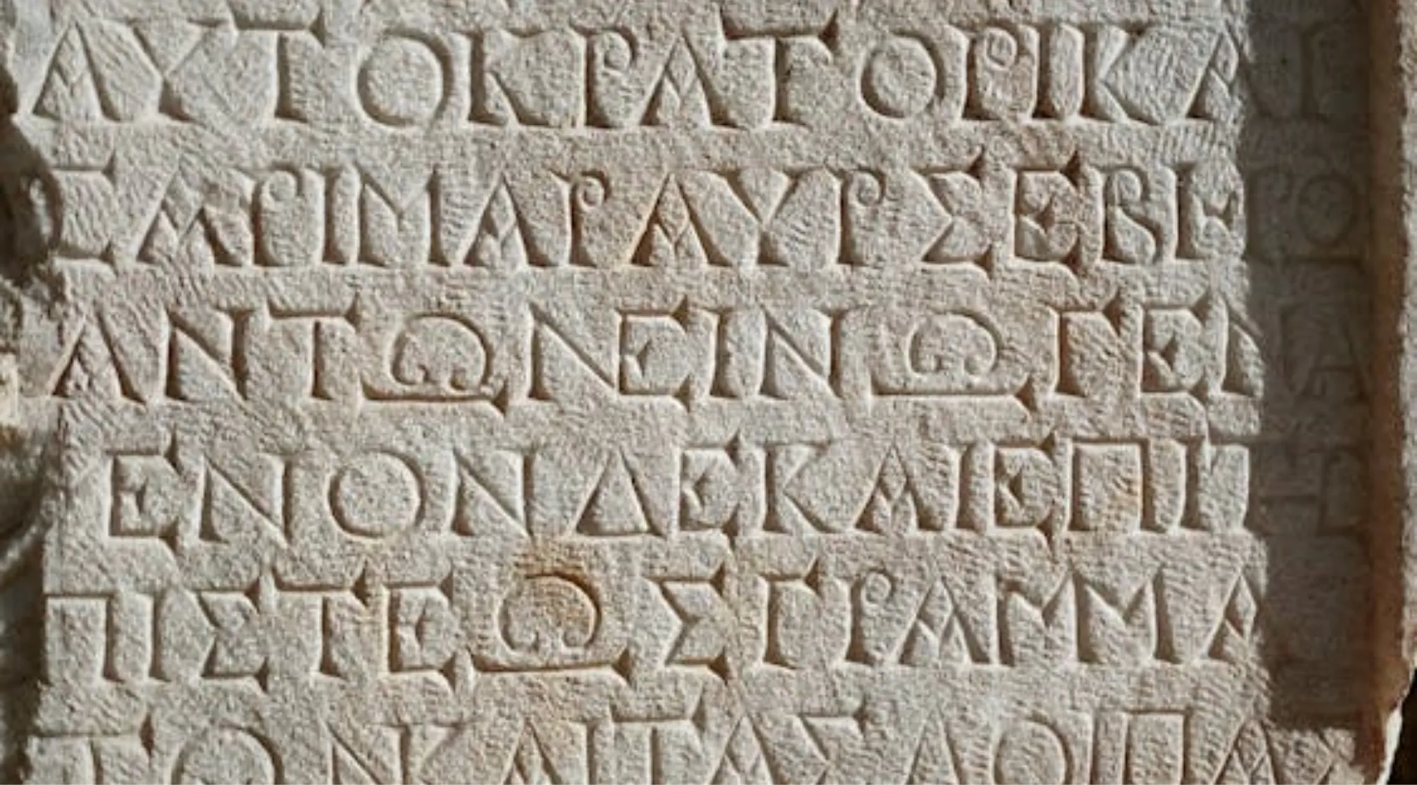 Ancient stone tablet inscribed with carved Greek alphabet letters. A visual representation for General Knowledge questions.