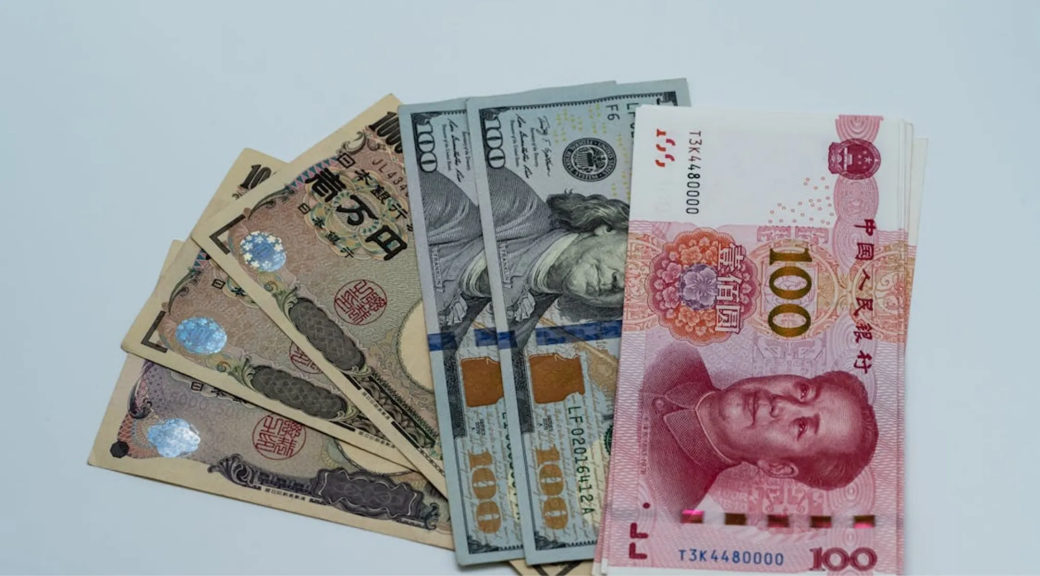General Knowledge: Yen, dollars, and yuan banknotes fanned out. Japan's currency, the Yen, is visible alongside US and Chinese money.
