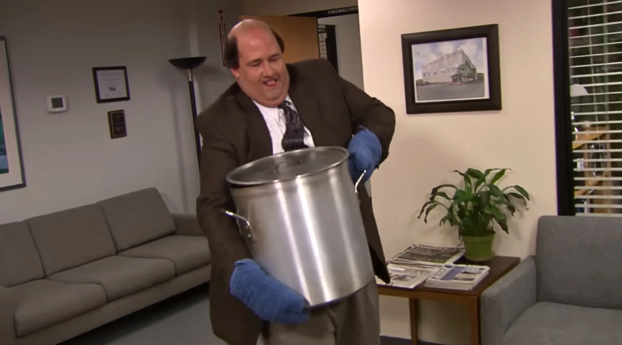 Kevin from The Office carrying a large pot of chili, about to spill it. Perfect for an Office Quiz.