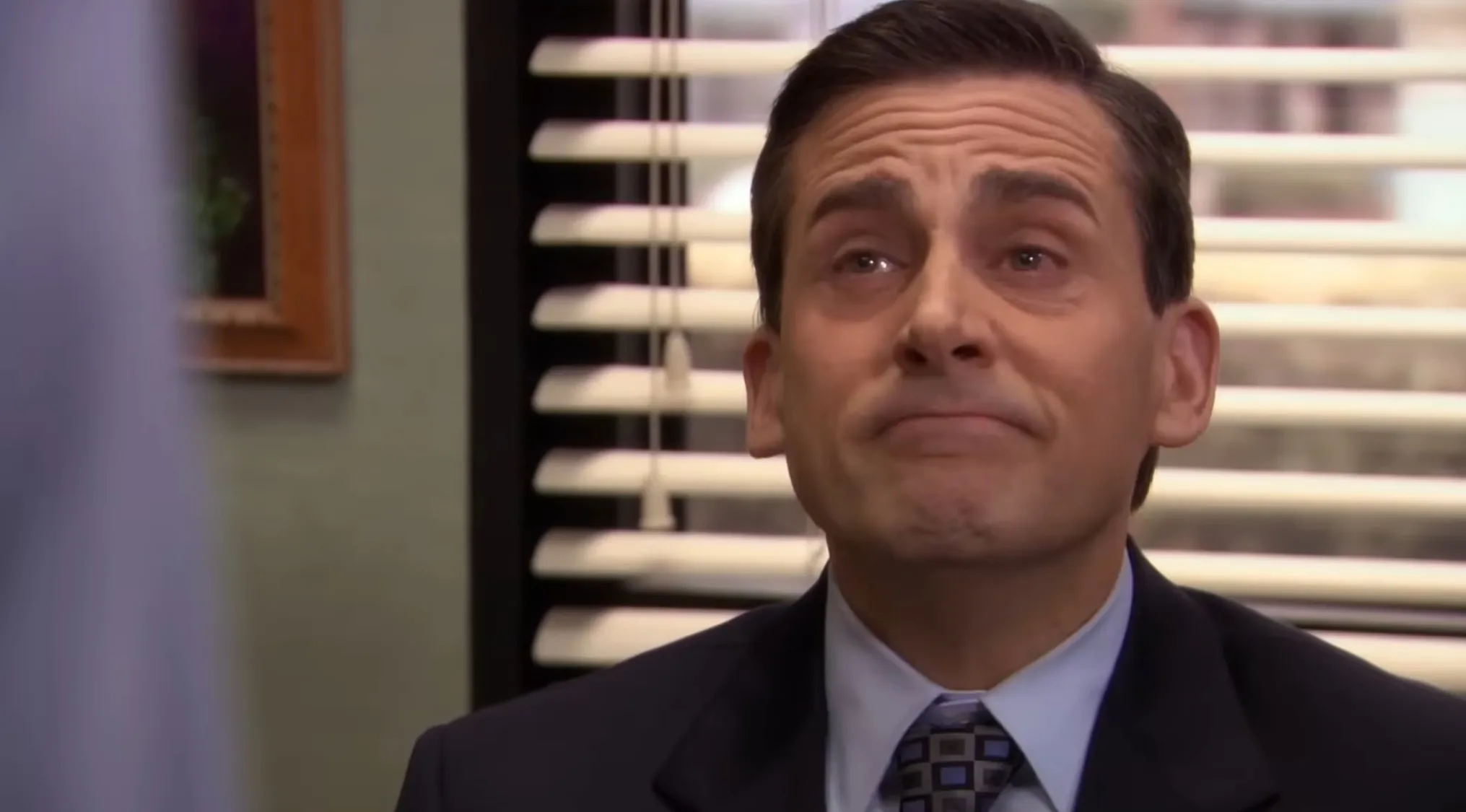 Michael Scott, wearing a suit and tie, looks teary-eyed in an Office Quiz. Why did he leave Dunder Mifflin?