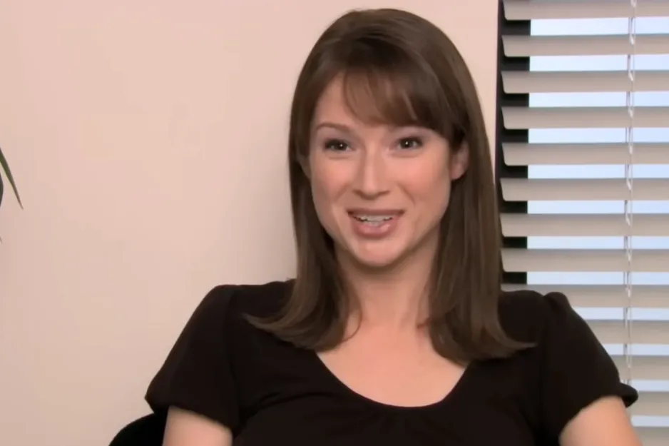 Erin, a young woman with brown hair and bangs, smiles while discussing her experience in foster care.