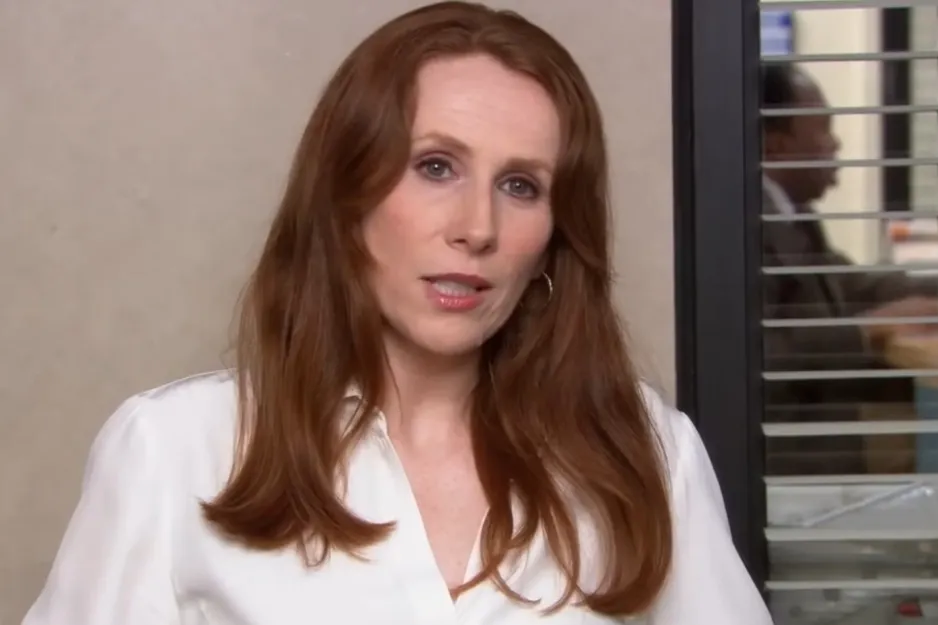 Nellie, with long auburn hair and wearing a white shirt, looking directly at the camera, discussing foster care experiences.