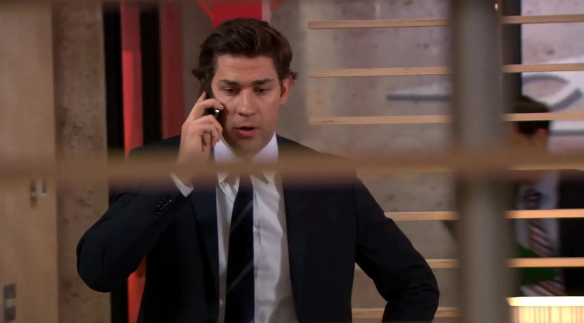 Jim Halpert on the phone at The Office, deep in thought, for The Office Quiz. What is Jim's dream field of work?