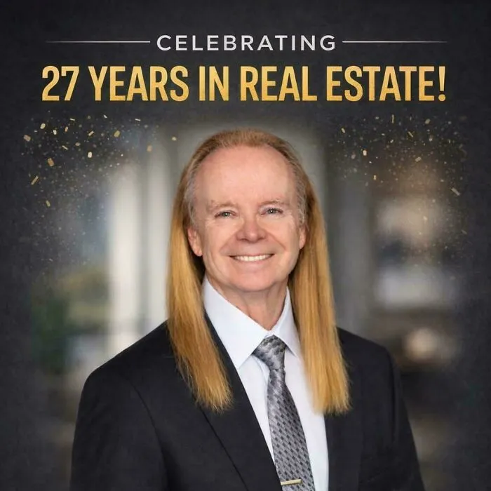 A man with long, blonde hair smiles, celebrating 27 years in real estate. The image shows his unique haircut.