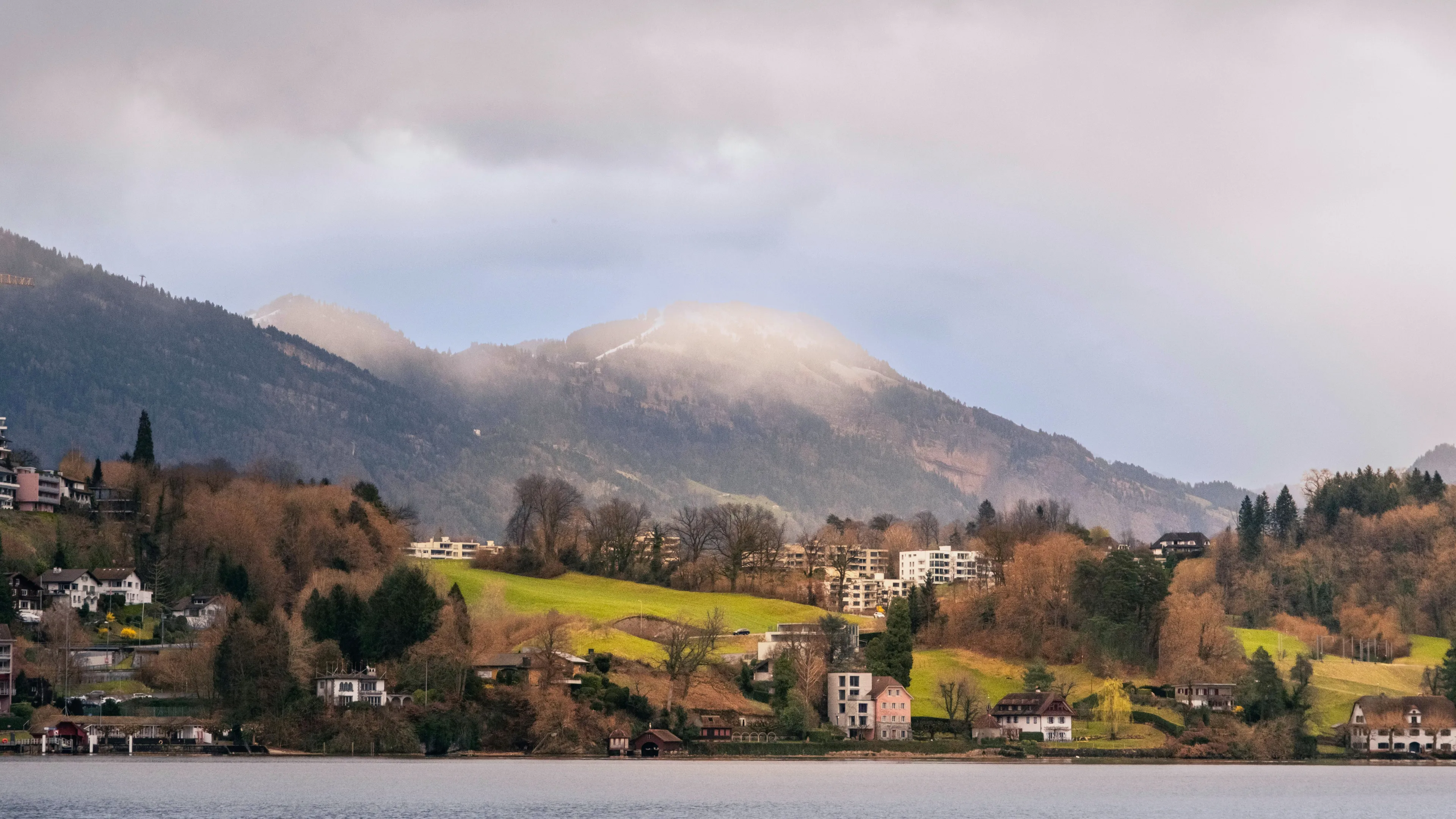 Lakeside village with mountains and foggy peaks, an example of General Knowledge scenery.