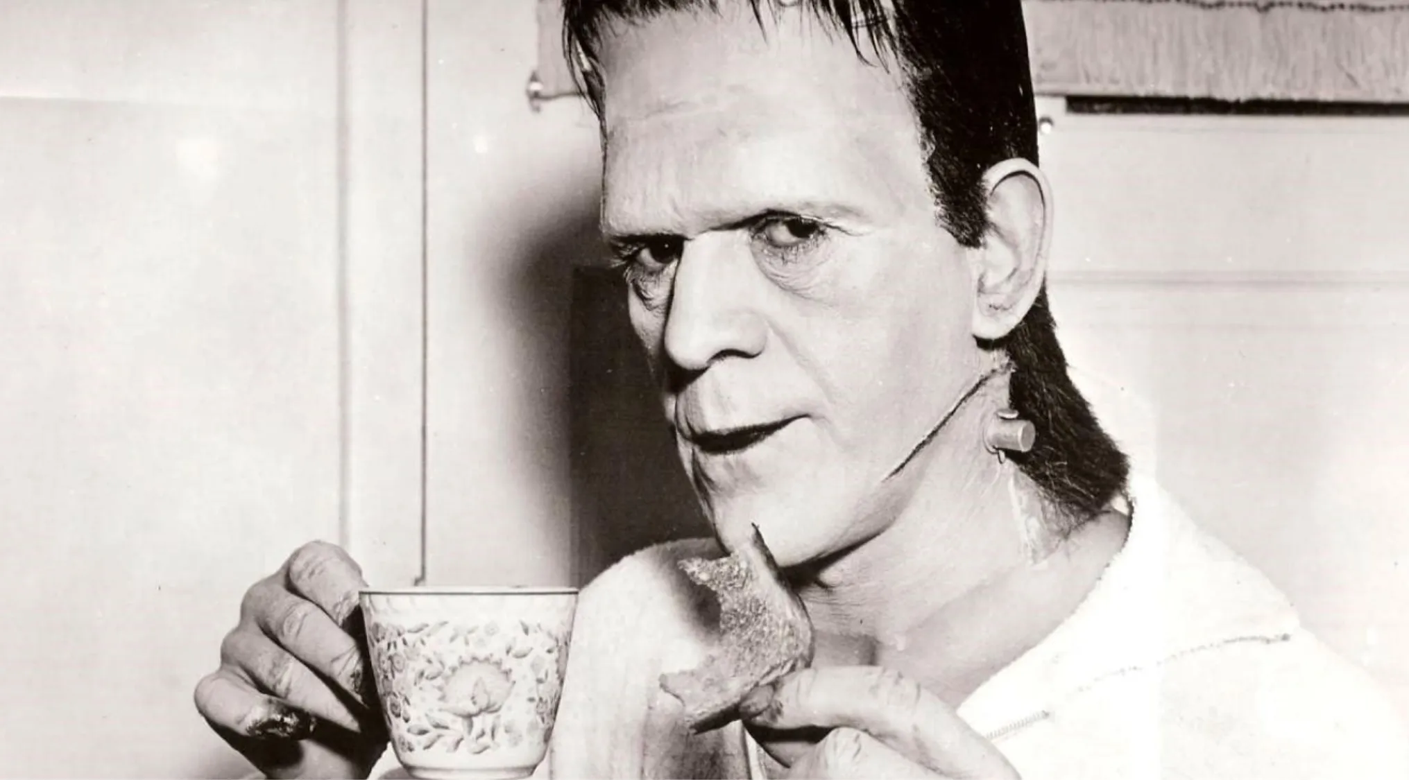Guess The Movie from this BTS image: Frankenstein's monster having a snack and tea on set, wearing a robe.