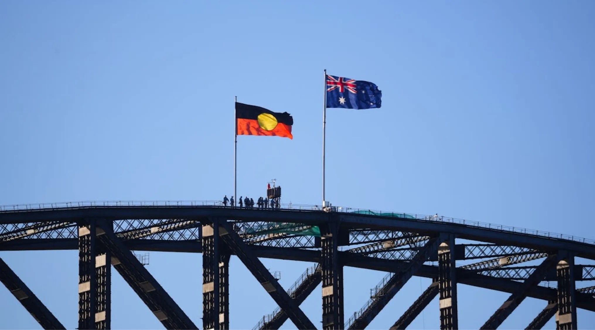 Australian Citizenship: Flags on a bridge against a blue sky, symbolizing a key part of the executive branch in Australia.