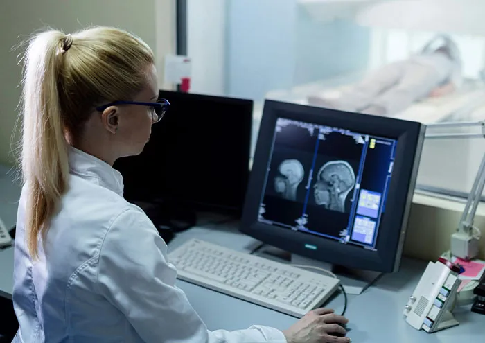 Scientist analyzing brain scans on computer in a lab exploring biggest theories not yet proven in science.